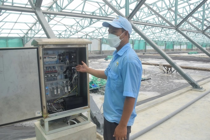 Anh Nhữ Văn Đạt, kỹ thuật trại nuôi A5 (Công ty TNHH Việt Úc - Phù Mỹ, Bình Định) bên hệ thống cho tôm ăn tự động. Ảnh: V.Đ.T.